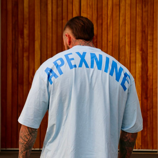 Person wearing a light blue t-shirt with 'APEXNINE' over size tee 