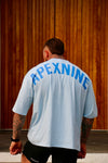 Person wearing a light blue t-shirt with 'APEXNINE' over size tee 