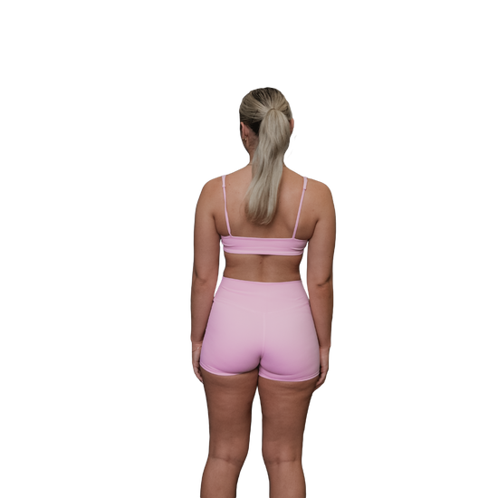 Woman wearing a pink sports bra rear view